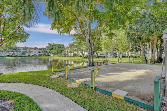 View of a residential building area with a pond and trees.