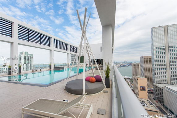 Rooftop swimming pool area with lounge seating and city skyline views.