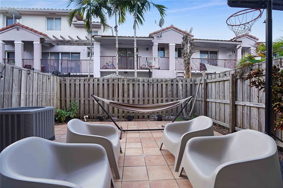 Outdoor area with a hammock, chairs, and a basketball hoop.