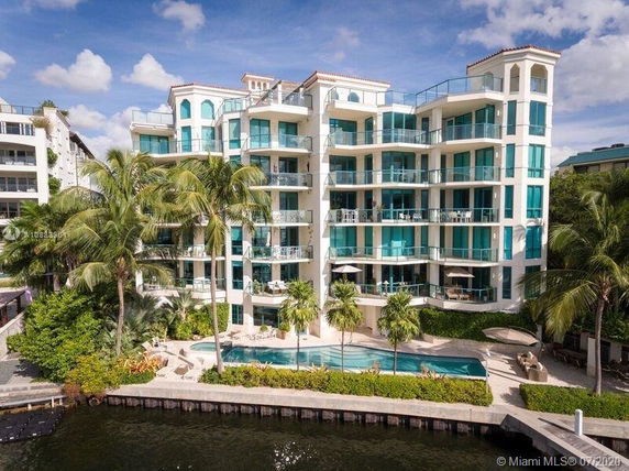 Front view of a multi-story modern apartment building with balconies and large windows.