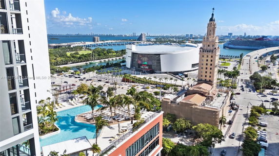 Panoramic view of a coastal cityscape with prominent buildings and a nearby swimming pool.