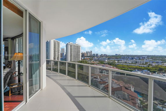 Panoramic view from a balcony showing cityscape and buildings.