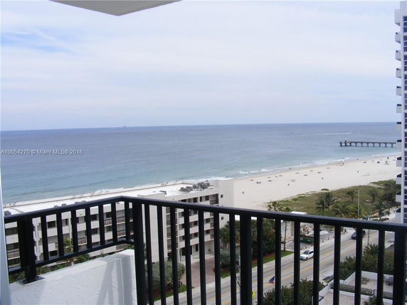 Panoramic view of the ocean and beach from a balcony.