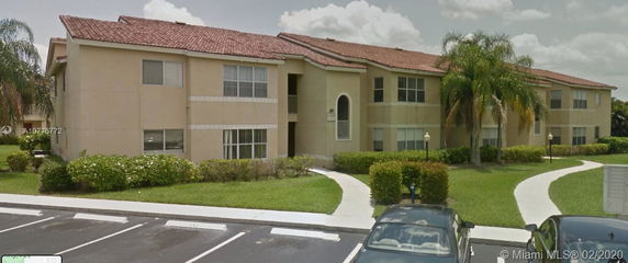 Front view of a two-story apartment building with a red-tiled roof.