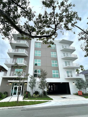 Front view of a modern multi-story apartment building with balconies.