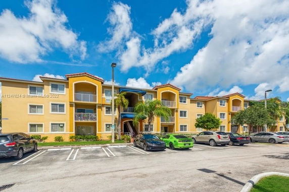 Front view of a three-story apartment building with parking area.