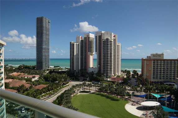 Panoramic view of tall buildings with an ocean backdrop.