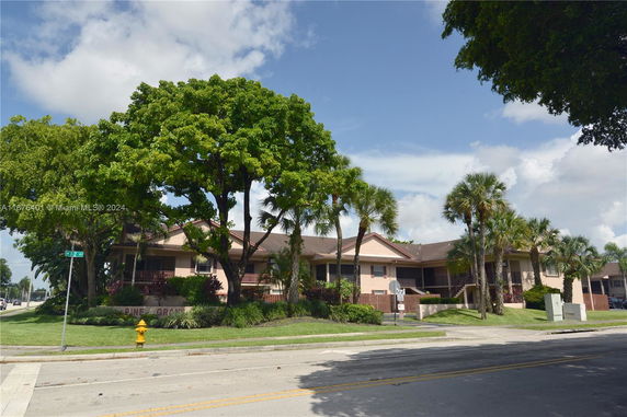 Front view of a multi-story residential building with a landscaped front.