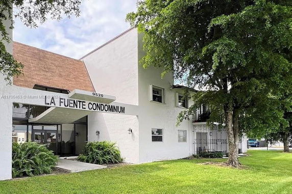 Front view of a condominium building with a white facade and a sign reading 'La Fuente Condominium'.