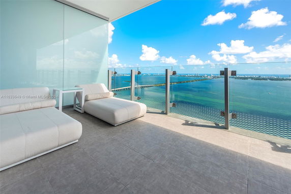 Balcony view overlooking a wide expanse of water and distant cityscape.