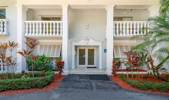 Front view of a two-story building with columns and a double-door entrance.
