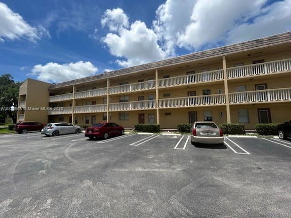 Front view of a three-story building with a parking lot.