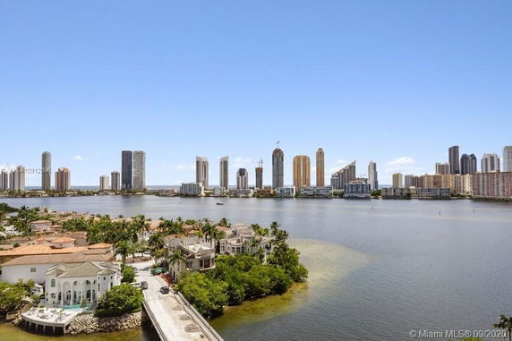 View of a bay area with high-rise buildings and houses along the shoreline.