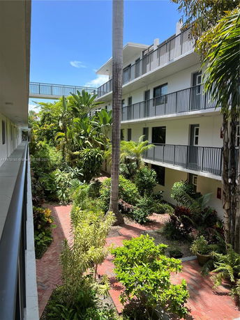View of a multi-story building with balconies and landscaped garden.