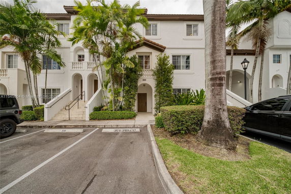 Front view of a multi-story house with stairs leading to the entrance.