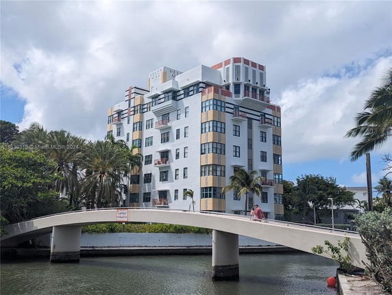 Front view of a multi-story building with a bridge in the foreground.