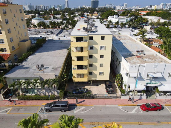 Front view of a mid-rise building with yellow exterior and balconies.