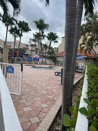 Outdoor play area with a playground and surrounding buildings.