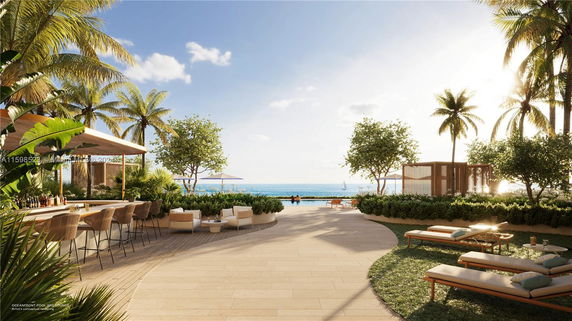Outdoor poolside lounge area overlooking the ocean with palm trees.