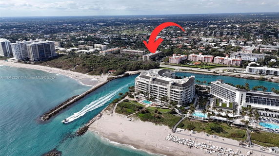 Aerial view of beachfront buildings with a waterway and beach.