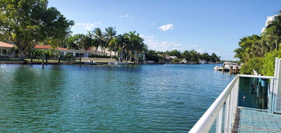 Scenic view of a waterfront area with houses and palm trees across a water channel.