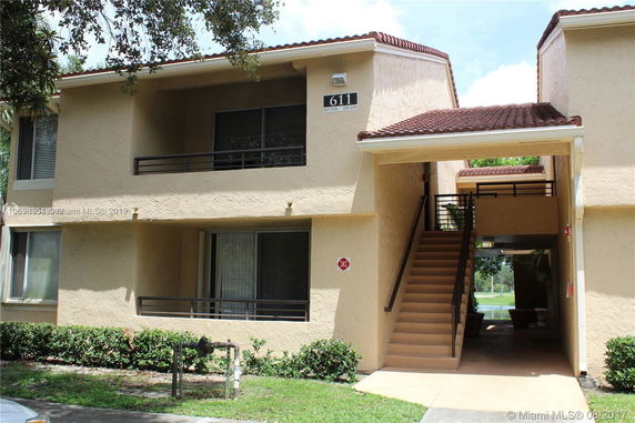 Front view of a two-story apartment building with exterior stairs.