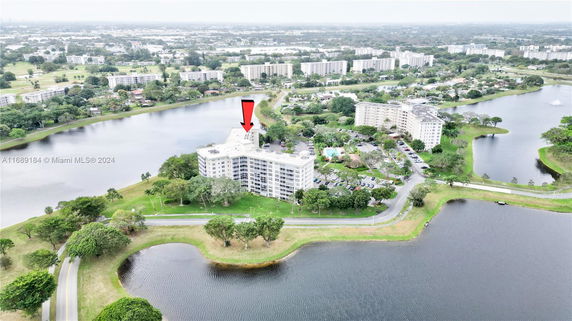 Aerial view of residential buildings surrounded by water bodies and greenery.