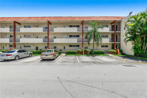 Front view of a three-story building with a parking area.
