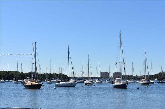 Panoramic view of a marina with multiple sailboats anchored in the water.