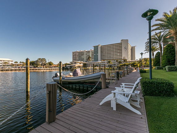 View of a waterfront area with a boat dock and a large building in the background.