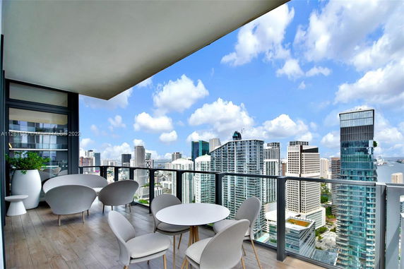 Balcony view overlooking a cityscape with modern high-rise buildings.