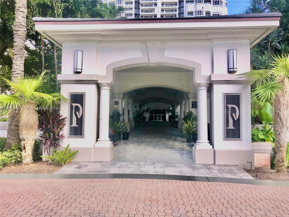 Front view of a building with columns and decorative elements.
