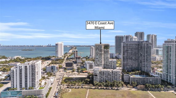 Aerial view of an urban area with multiple high-rise buildings and a view of the ocean in Miami.