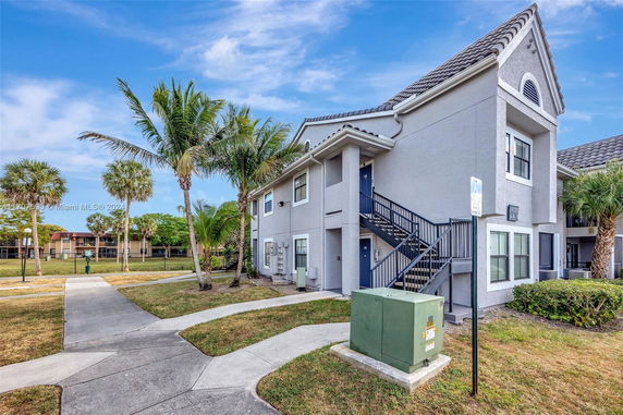 Front view of a two-story residential building with outdoor staircase.