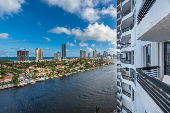 Panoramic view from a high-rise building showing a city skyline and waterfront homes.