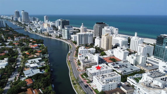 Aerial panoramic view of a coastal city with high-rise buildings along a waterfront and beaches.