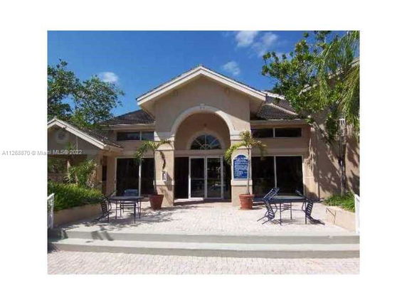 Front view of a single-story building with a large arched entryway and glass doors.