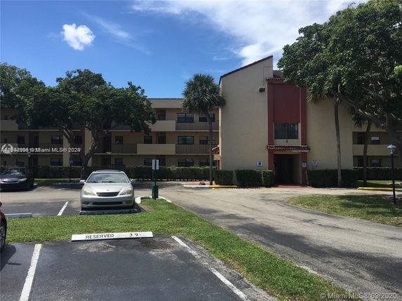 Front view of a multi-story residential building with balconies and a main entrance.