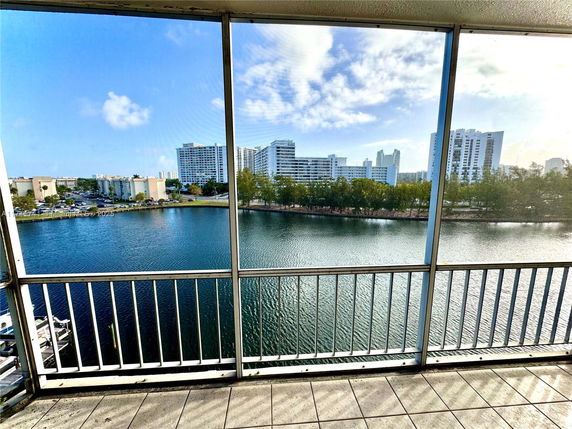 Panoramic view from a balcony overlooking water and distant buildings.