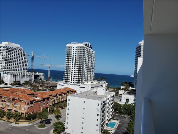 View of tall modern buildings near the ocean, seen from a higher vantage point.