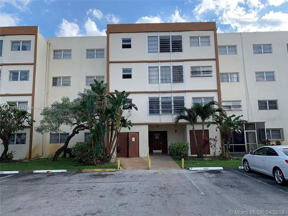 Front view of a multi-story residential building with a parking space in front.