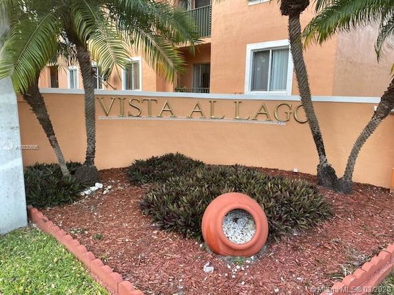 Front view of a multi-story building with a sign 'Vista Al Lago' on a decorative wall.