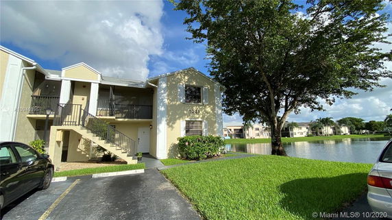 Front view of a two-story residential building with an external staircase.