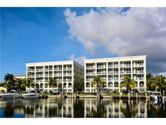 Front view of two adjacent multi-story residential buildings with balconies, situated by the waterfront.