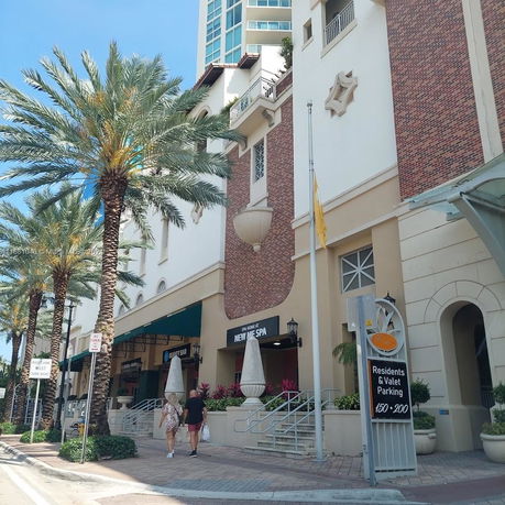 Front view of a multi-story building with retail signage and decorative architectural elements.