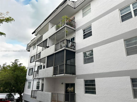 Front view of a multi-story apartment building with balconies.