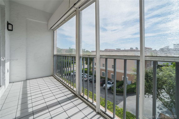 Balcony view overlooking parking area and neighboring buildings.