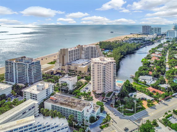 Panoramic view of buildings near a beach with a canal and surrounding residential area.