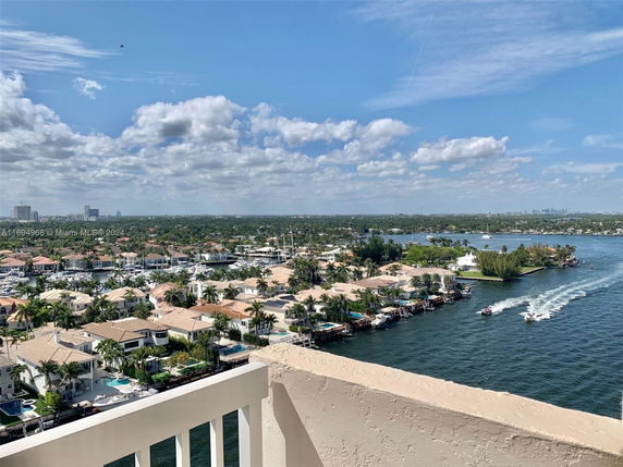 View of residential area with waterfront homes and boats on a river.