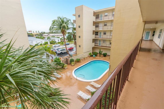View of an outdoor swimming pool within a multi-story residential complex.